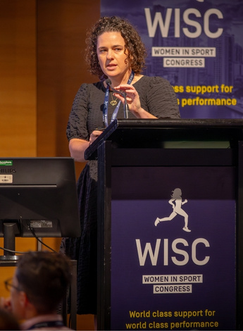 The photo is of Melissa Haberfield presenting at the Women in Sports Congress. 
